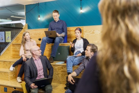 Henkilöitä istuu TEK Loungen katsomossa Tampereella.