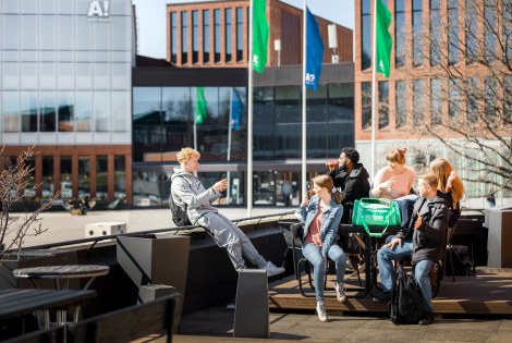 Opiskelija ottaa kuvaa kaveriporukastaan terassilla Aalto-yliopistolla