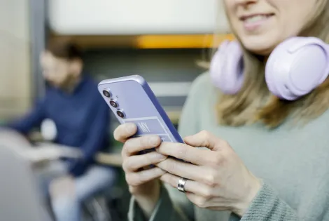 Lähikuvassa henkilö lukee puhelimeltaan jotain.