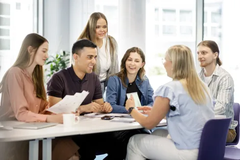 iloiset ihmiset juttelevat pöydän äärellä