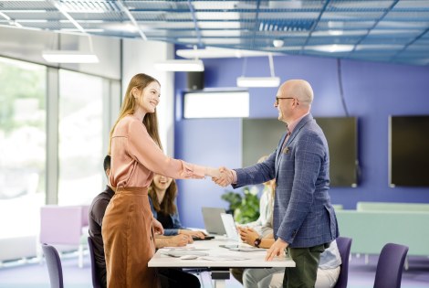 Kaksi henkilöä kättelee.