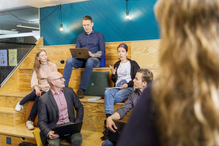 Henkilöitä istuu TEK Loungen katsomossa Tampereella.