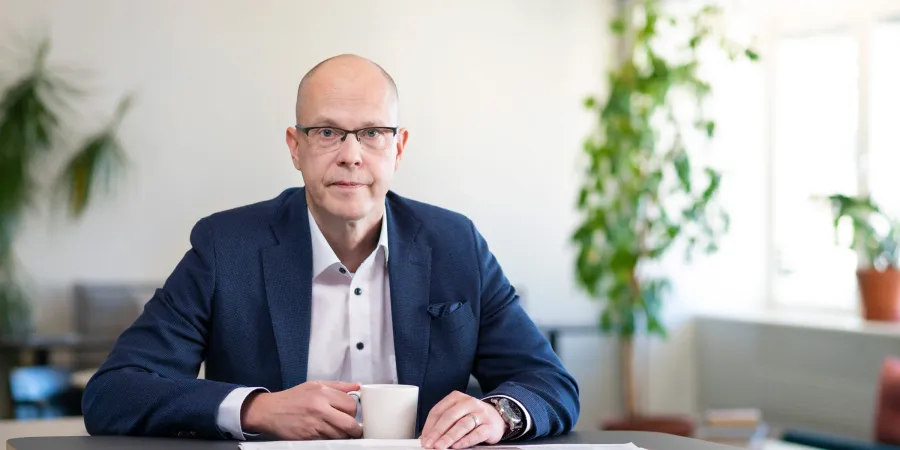 Teemu Hankamäki katsoo kameraan työpöydän ääressä.
