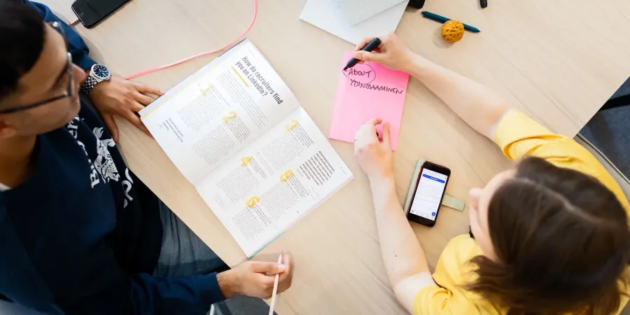 Kaksi henkilöä tarkastelee Työkirjan artikkelia LinkedInistä