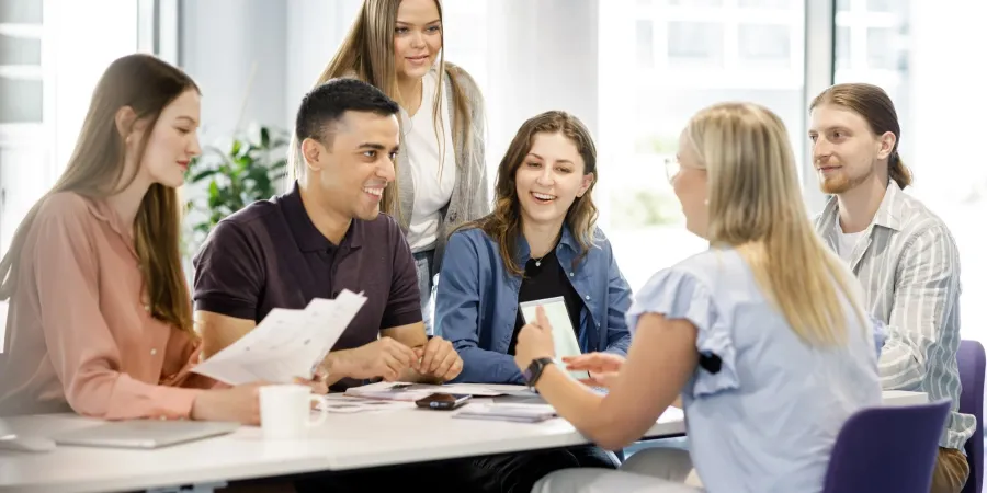 iloiset ihmiset juttelevat pöydän äärellä